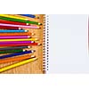 Colored pencils and notepad on wooden table
