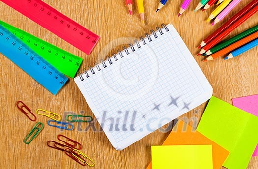 Colored pencils and notepad on wooden table Colored pencils and notepad on wooden table