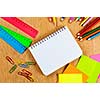 Colored pencils and notepad on wooden table