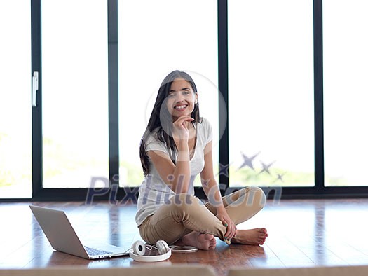 beautiful young woman relax and work on laptop computer modern home office while listening musin on white headphones beautiful young woman relax and work on laptop computer modern home office while listening musin on white headphones