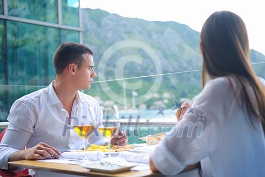 happy young couple having lanch at beautiful restaurant on the beach
