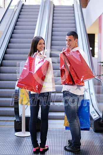 happy young couple with bags in shopping centre mall happy young couple with bags in shopping centre mall