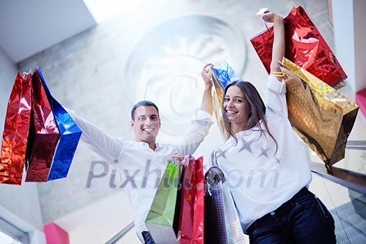 happy young couple with bags in shopping centre mall happy young couple with bags in shopping centre mall