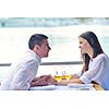 happy young couple having lanch at beautiful restaurant on by the sea on  beach
