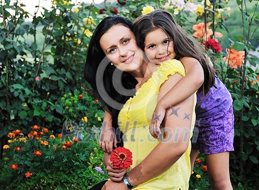 beautiful mom and daughter outdoor in garden together with flower have fun and hug beautiful mom and daughter outdoor in garden together with flower have fun and hug