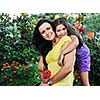 beautiful mom and daughter outdoor in garden  together with flower have fun and hug 
