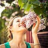 Beautiful young woman smelling white jasmin flowers