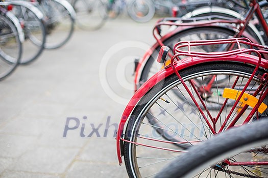 Bike rental service - Many bikes standing in bike stands, available for rent as a great mean of transport in the city Bike rental service - Many bikes standing in bike stands, available for rent as a great mean of transport in the city