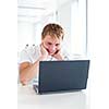 Handsome male student using a computer in a university library/study room (shallow DOF, color toned image)