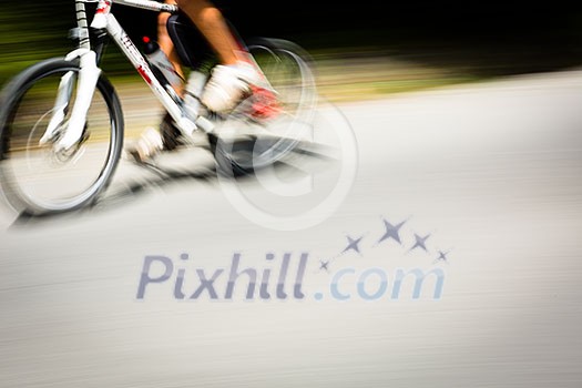 Cyclist on a road bike going fast (motion blur technique is used to convey movement; colour toned image) Cyclist on a road bike going fast (motion blur technique is used to convey movement; colour toned image)