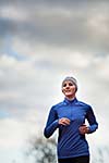 Portrait of a woman running against against blue sky