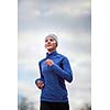 Portrait of a woman running against against blue sky