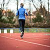Young woman running at a track and field stadium