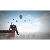 Young businessman sitting on roof of building