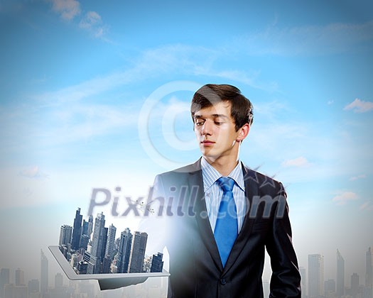 Handsome businessman holding model of modern city Handsome businessman holding model of modern city