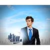 Handsome businessman holding model of modern city