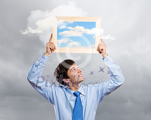 Handsome young man holding frame with pictures Handsome young man holding frame with pictures
