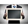 Close up of businessman holding blank frame. Place for text