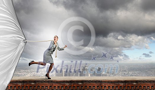 Young businesswoman running and pulling white blank banner Young businesswoman running and pulling white blank banner