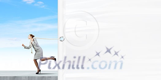 Young businesswoman running and pulling white blank banner Young businesswoman running and pulling white blank banner