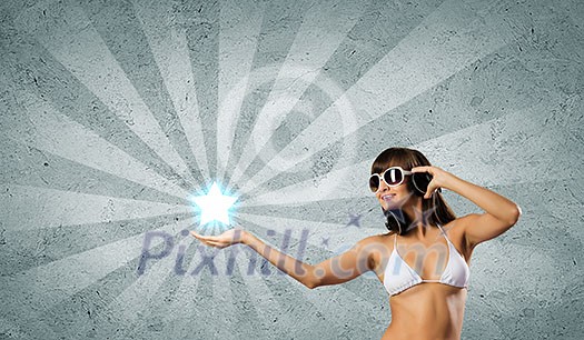 Young attractive girl in bikini wearing headphones touching media icon Young attractive girl in bikini wearing headphones touching media icon