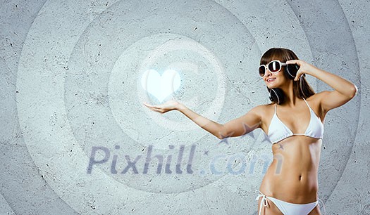 Young attractive girl in bikini wearing headphones touching media icon Young attractive girl in bikini wearing headphones touching media icon