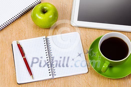 Tablet pc cup of coffee and notepad at table Tablet pc cup of coffee and notepad at table