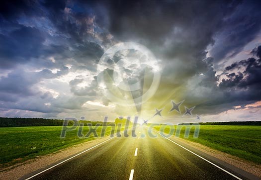 Travel concept background - road and stormy dramatic sky on sunset