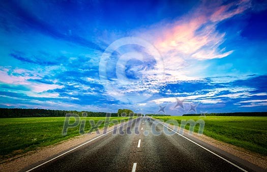 Travel concept background - road and stormy dramatic sky on sunset Travel concept background - road and stormy dramatic sky on sunset