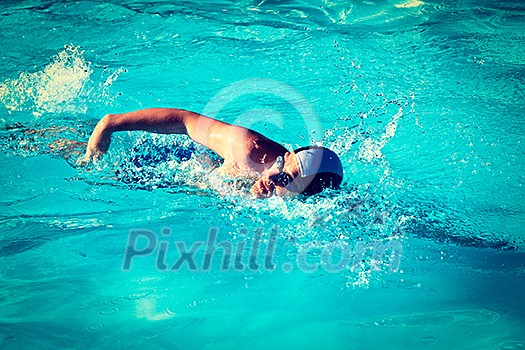 Vintage retro effect filtered hipster style image of athletic Man swimming in the pool Vintage retro effect filtered hipster style image of athletic Man swimming in the pool