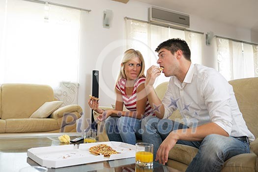 happy young couple eat fresh pizza at home relaxing and watch tv happy young couple eat fresh pizza at home relaxing and watch tv
