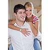 Relaxed young  couple watching tv at home in bright living room