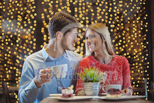 romantic evening date in restaurant  happy young couple with wine glass tea and cake