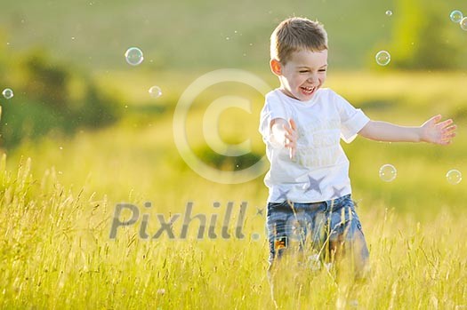happy young beautiful child have fun on eadow with soap bubbles toy happy young beautiful child have fun on eadow with soap bubbles toy