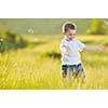 happy young beautiful child have fun on eadow with soap bubbles toy