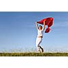 beautiful young and healthy woman run and jump on meadow at sunny day with red scarf