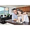 happy young couple have fun in modern wooden  kitchen indoor while preparing fresh food