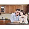 happy young couple have fun in modern wooden  kitchen indoor while preparing fresh food