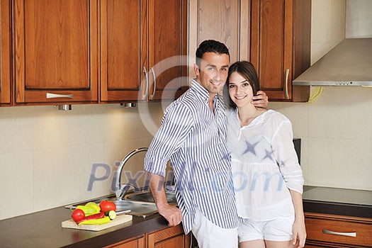 happy young couple have fun in modern wooden kitchen indoor while preparing fresh food happy young couple have fun in modern wooden kitchen indoor while preparing fresh food