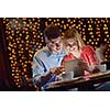 happy young couple with a tablet computer in restaurant