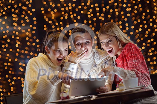happy girls group looking at a pc tablet in a home interior and have fun happy girls group looking at a pc tablet in a home interior and have fun