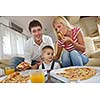 happy young family eating tasty pizza with cheesa and dring healthy and fresh orange juice