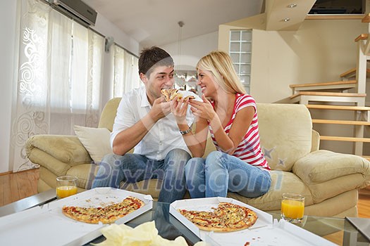 happy young couple eat fresh pizza at home relaxing and watch tv happy young couple eat fresh pizza at home relaxing and watch tv