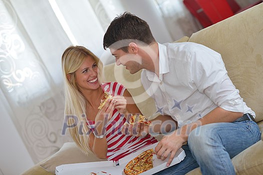 happy young couple eat fresh pizza at home relaxing and watch tv happy young couple eat fresh pizza at home relaxing and watch tv