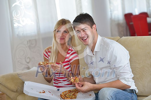 happy young couple eat fresh pizza at home relaxing and watch tv happy young couple eat fresh pizza at home relaxing and watch tv