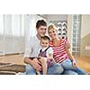 happy young family with kids in bright modern living room have fun and looking big flat lcd tv