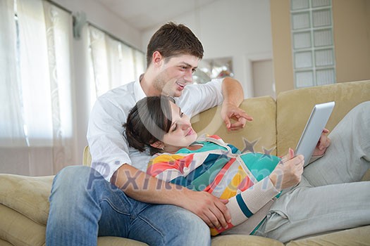 pregnant woman with her husband have fun relax and using tablet comture at modern home pregnant woman with her husband have fun relax and using tablet comture at modern home
