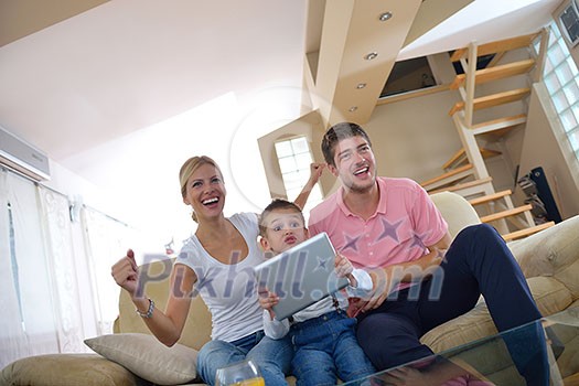 happy young family using tablet computer at modern home for playing games and education happy young family using tablet computer at modern home for playing games and education