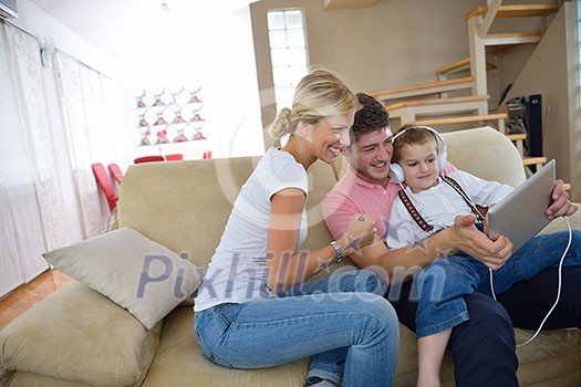 happy young family using tablet computer at modern home for playing games and education happy young family using tablet computer at modern home for playing games and education