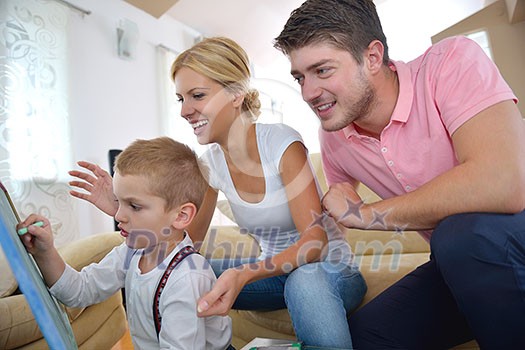 happy young family teach leassons and prepare their son for school while draw on board at home happy young family teach leassons and prepare their son for school while draw on board at home
